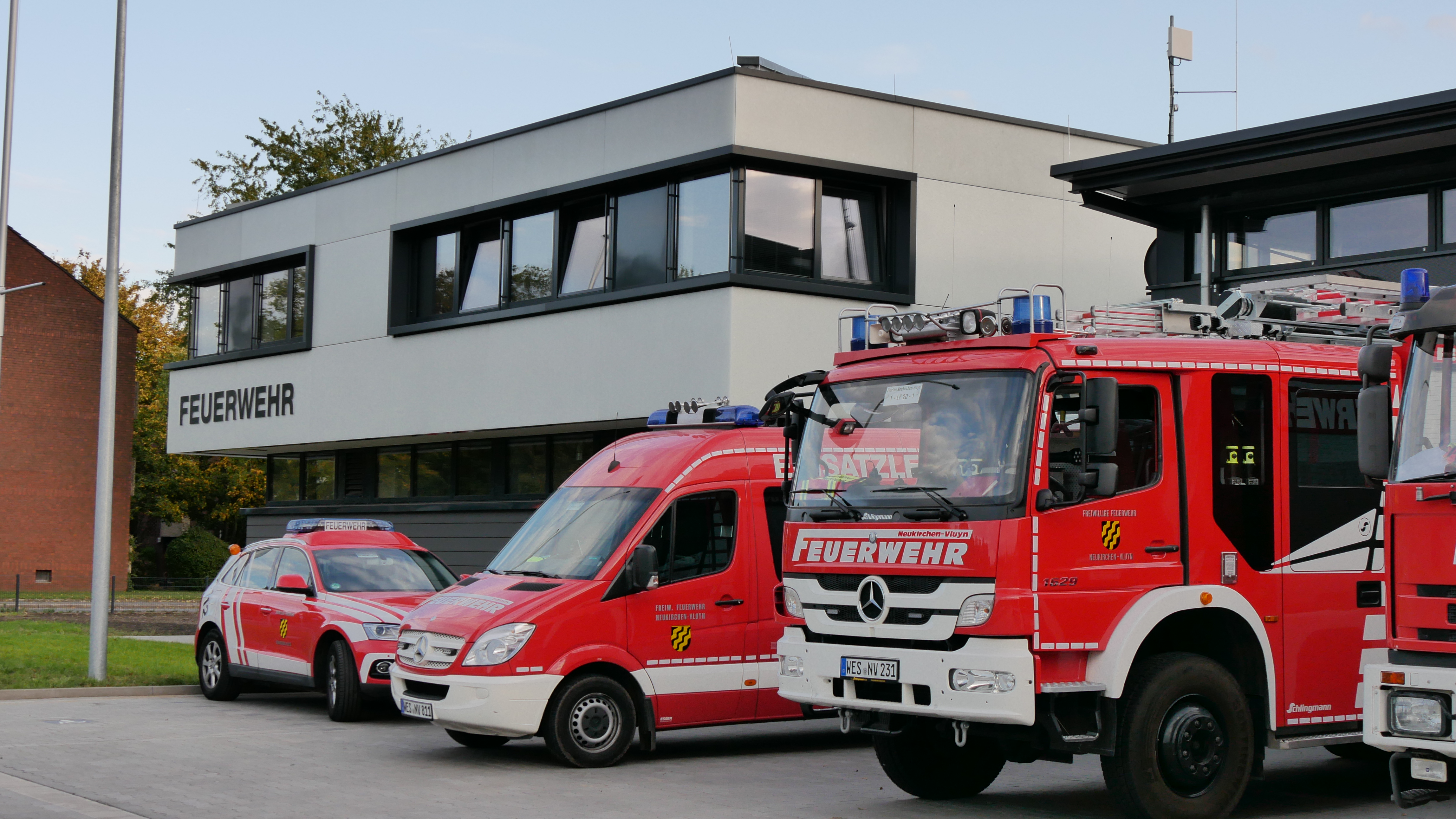 Feuerwehrfahrzeuge stehen vor Gebäude